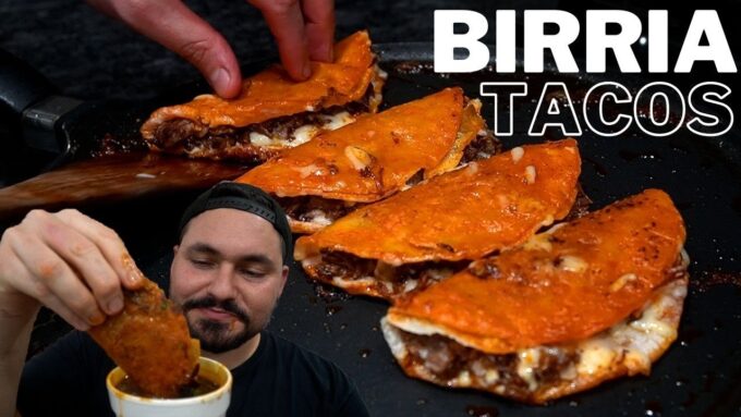 Imagen de tacos de birria: varios tacos dorados rellenos de carne sobre una plancha, con una persona sumergiendo uno en un tazón de consomé y el texto "BIRRIA TACOS". - Recetas Chidas