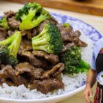 Plato de lomo salteado con brócoli y arroz en un plato azul, con un cocinero sonriente sosteniendo otro plato similar al fondo. - Recetas Chidas