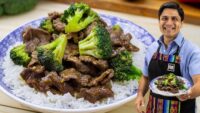 Plato de lomo salteado con brócoli y arroz en un plato azul, con un cocinero sonriente sosteniendo otro plato similar al fondo. - Recetas Chidas
